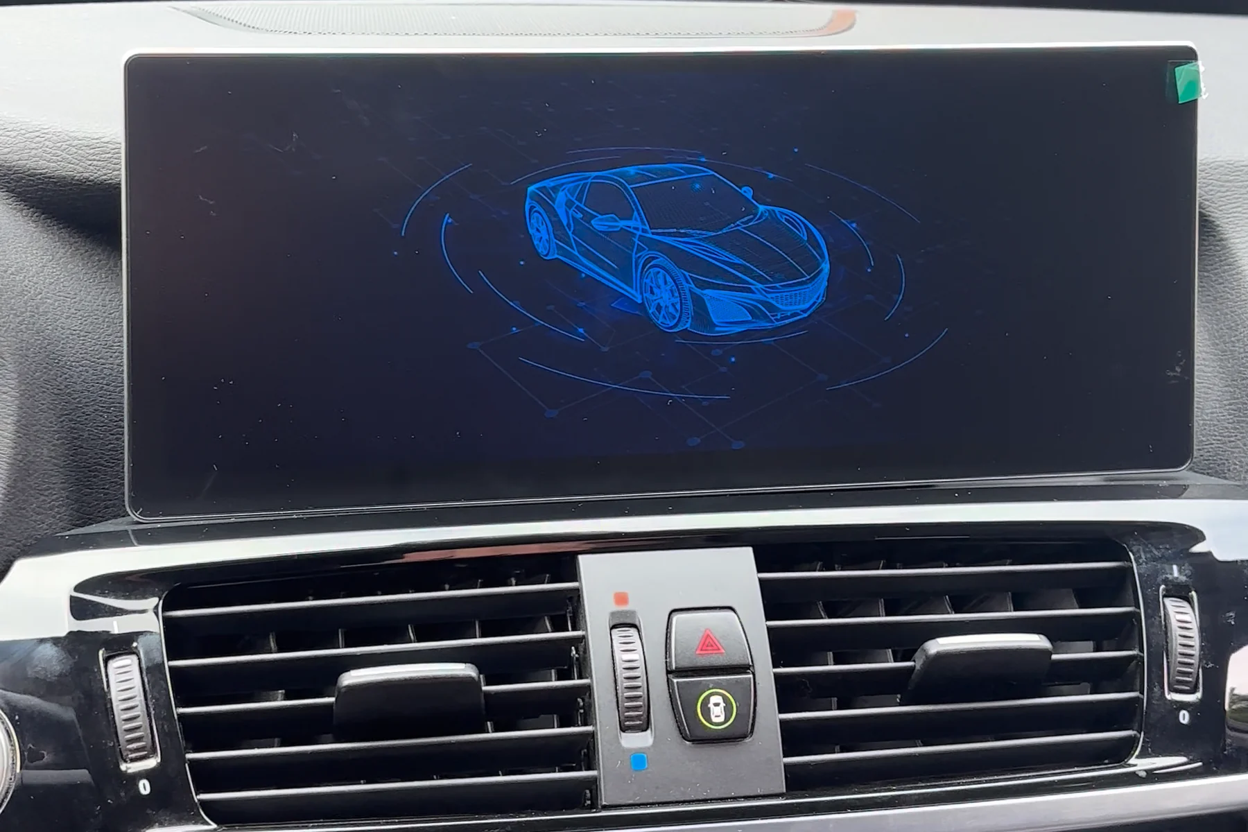 Widescreen replacement display installed in a BMW X3 dashboard, showing its startup screen